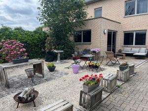 a patio with flowers and tables and chairs and a building at Casa Leopardo in Hasselt