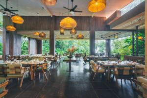 a restaurant with tables and chairs and lights at Los Altos Resort in Manuel Antonio