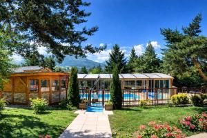 a house with a swimming pool in a yard at Logis Hotel Le Lac in Embrun