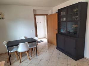a dining room with a black table and white chairs at Fewo Holtwicker Ei in Rosendahl +13 photos