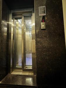 an elevator with a glass door in a building at Vizag Urban Nest in Visakhapatnam +9 photos