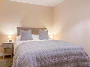 a bedroom with a large bed with white sheets and pillows at The Coach House in Kettlewell