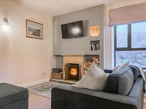 a living room with a couch and a fireplace at The Coach House in Kettlewell