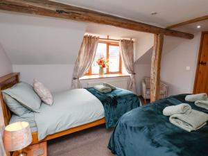 a bedroom with two beds and a window at Boundcliffe Farm in Allerston