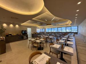 a restaurant with tables and chairs in a room at Hotel Mepas in Mostar