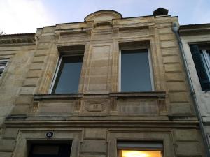 un edificio de piedra alto con ventanas laterales en Le Saint Fort - Coeur de Bordeaux, en Burdeos