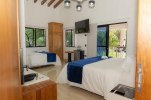 a hotel room with two beds and a television at Ecohotel Dubai del Oriente in El Peñol