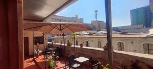 a patio with an umbrella and tables and chairs at Peter's Hostel in Arequipa