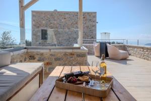 a table with wine glasses and a tray of food at Lakkos Villas in Kardamyli