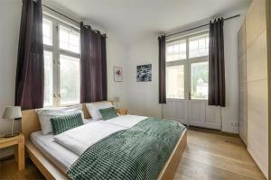 a bedroom with a large bed and two windows at Villa Benedikt in Bad Gastein