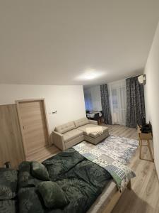 a living room with a bed and a couch at GINGER apartman in Hajdúszoboszló
