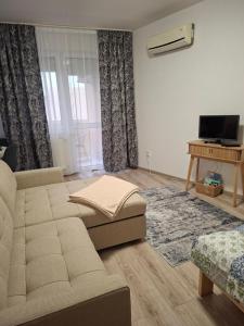 a living room with a couch and a tv at GINGER apartman in Hajdúszoboszló