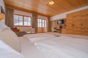 a large bedroom with two beds and a couch at Hotel Langeck in Maria Alm am Steinernen Meer +119 photos