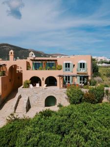 a large house in the middle of a field at Beachfront Majestic Villa in Liaropá