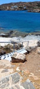 a rock sitting next to a fence next to the water at Beachfront Majestic Villa in Liaropá