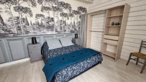 a bedroom with a bed and a wall with trees at La Flambée in Blond