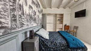 a bedroom with a bed and a painting on the wall at La Flambée in Blond