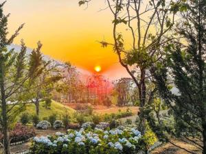 a painting of a garden with a sunset in the background at Làng Hương Village in Teurnoum +17 photos