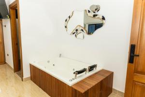 a bath tub in a bathroom with a mirror at Ecohotel Dubai del Oriente in El Peñol +110 photos