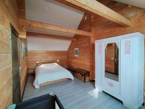 a bedroom with a bed in a wooden cabin at Aux Gîtes d'Orient in Géraudot