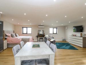 a bedroom with a bed and a table in a room at Aloe Lodge in Diss