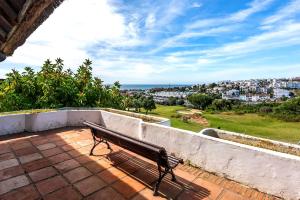 a bench sitting on a patio with a view of a city at Fuente de la Duquesa in Manilva +6 photos