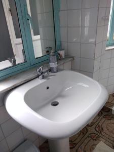 a white sink in a bathroom with a mirror at Casa Abenante in Corigliano Calabro +30 photos
