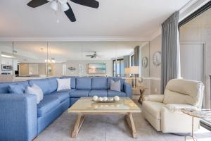a living room with a blue couch and a table at Phoenix X 506 condo in Orange Beach