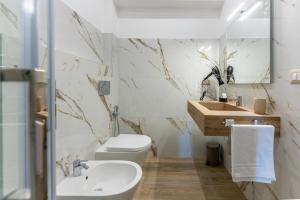 a bathroom with a white toilet and a sink at Villa Carducci in Comacchio +69 photos