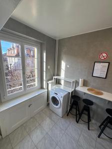 a laundry room with a washing machine and a window at Cosy studio a Lausanne center in Ouchy