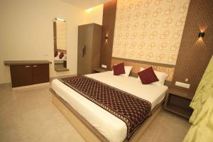 a bedroom with a large bed in a room at Thendral inn in Vellore +9 photos