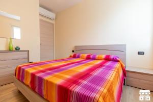 a bedroom with a bed with a colorful striped comforter at CASA MIA by Design Studio in Colico