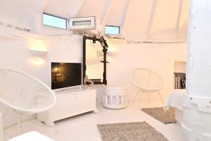 a living room with white furniture and a large mirror at Windmill of Mykonos in Mikonos