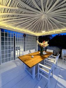 a wooden table and chairs on a patio at Windmill of Mykonos in Mikonos +14 photos