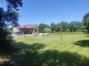 a large field with two red poles in the grass at Apartmani PARADISO in Čapljina