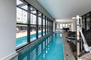 a swimming pool with windows in a building at Ibiza 2410 · Vista incrível: Piscina, Academia e Bem Localizado in Curitiba