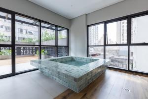 a jacuzzi tub in a room with large windows at Ibiza 2410 · Vista incrível: Piscina, Academia e Bem Localizado in Curitiba +26 photos