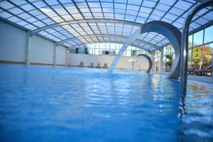 a swimming pool with a water slide in a building at Yalçın Resort Hotel in Korgan +15 photos