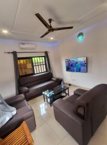 a living room with couches and a ceiling fan at Villa Moderne 4 Chambres avec Suite in Loué