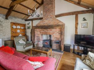 a living room with a brick fireplace and a couch at Glanyrafon Smithy in Llandysul