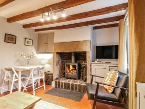 a living room with a fireplace and a table and chairs at 5 Belper Lane End in Belper