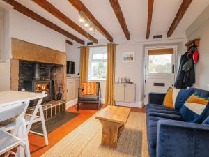 a living room with a blue couch and a fireplace at 5 Belper Lane End in Belper