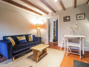 a living room with a blue couch and a table at 5 Belper Lane End in Belper +26 photos