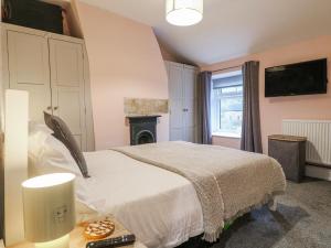 a bedroom with a bed and a fireplace at 5 Belper Lane End in Belper