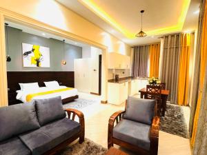 a hotel room with a bed and a couch and a kitchen at Pieme Hotel Residence in Migade