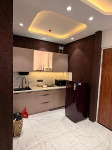 a kitchen with a refrigerator and a sink at PATEL Residency in Ghaziabad