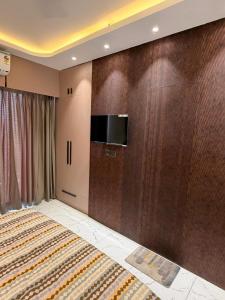 a bedroom with a bed and a tv on a wall at PATEL Residency in Ghaziabad