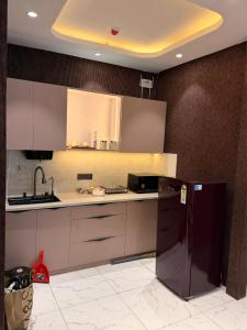a kitchen with a refrigerator and a sink at PATEL Residency in Ghaziabad +12 photos