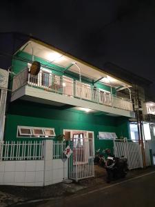 a green building with a balcony and a motorcycle parked in front at Edotel Tebe Syariah in Rampal