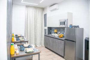 a kitchen with a stainless steel refrigerator and a table at Giulio Cesare Luxury Rooms in Rome